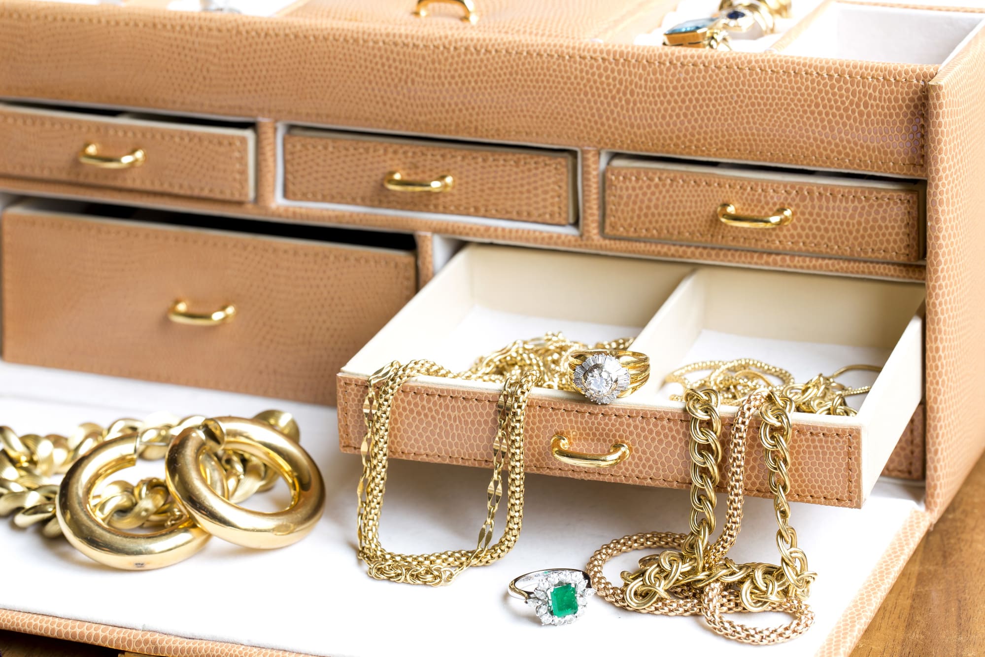 Boîte à bijoux ouverte avec bijoux en or et bagues illustrant leur valeur potentielle lors d’un grand ménage